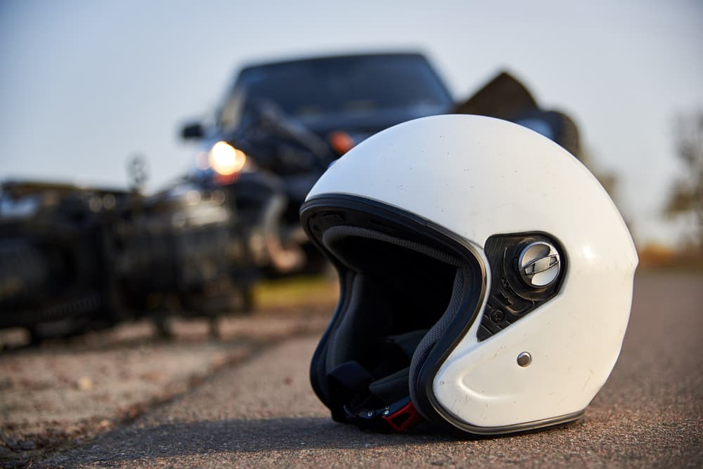 A helmet on the road after a  car collides with a motorcycle