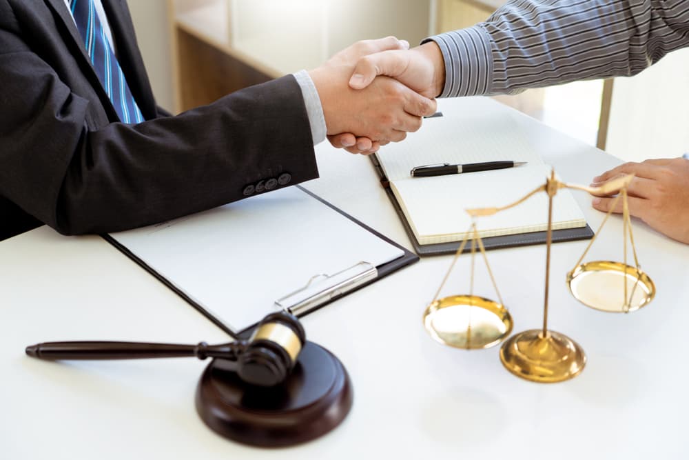 A lawyer shaking hands with a client after a consultation, discussing a contract agreement in a courtroom setting. Represents legal services and client trust.